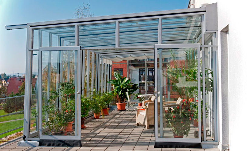 Un cierre de terraza en armonía con tu hogar puede albergar muchas plantas en su interor